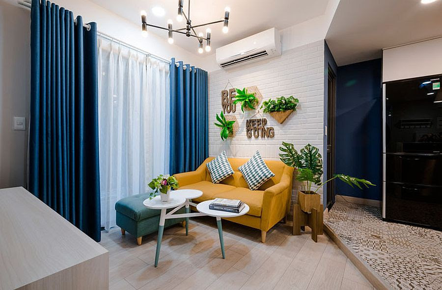 Không gian tiếp khách tuy nhỏ hẹp nhưng được bài trí khá ấn tượng với sofa vàng, xanh lệch tông và bàn trà 3 khay mới lạ. bàn trà 3 khay