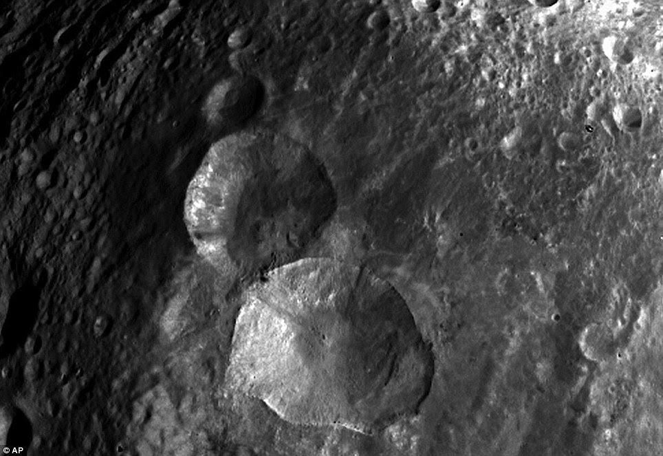 Rough terrain: A set of three craters - nicknamed 'Snowman' - are seen in this image of the northern hemisphere of Vesta taken by Nasa's orbiting Dawn spacecraft from a distance of about 3,200miles