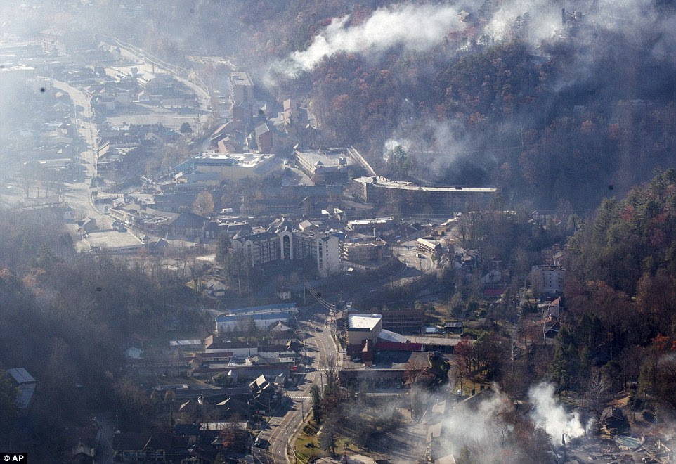 Thousands of people raced through a hell-like landscape to escape wildfires that killed several people and destroyed hundreds of homes in the Great Smoky Mountains
