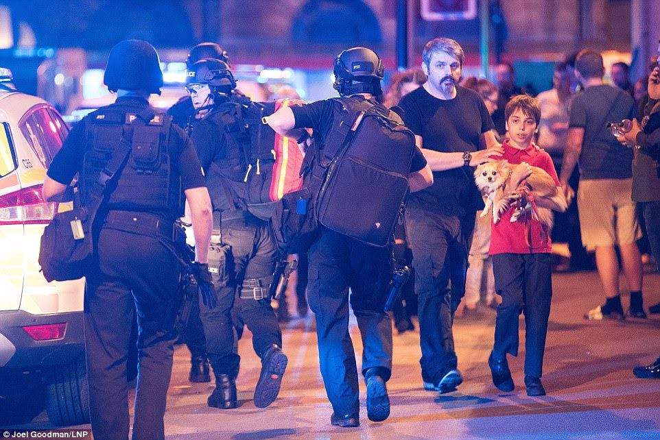 A boy accompanied by an adult carries a dog outside the arena, where crowds of police were gathered. Greater Manchester Police said they will be releasing a contact number for missing people as soon as possible