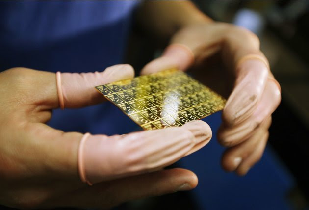 An employee checks a gold Combibar at a plant of gold refiner and bar manufacturer Valcambi SA in the southern Swiss town of Balerna