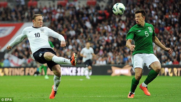 Off target: Wayne Rooney lobs a shot wide of the goal for England