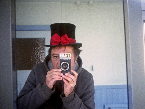 reflected self-portrait with Yashica Rapide camera and bowed top hat by pho-Tony