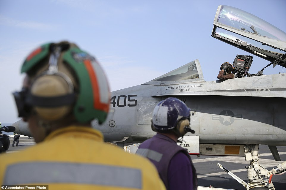 The pilot of an F-18 fighter jet prepares to take off from the USS George H.W. Bush as it travels toward the Strait of Hormuz. President  Trump has warned that Iranian forces will be blown out of the water if they challenge U.S. naval vessels