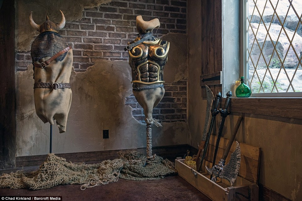 Ready for battle: A sword rack is just one of the fantasy-themed elements to the basement, which also includes practice dummies covered in suits of armor (pictured left)