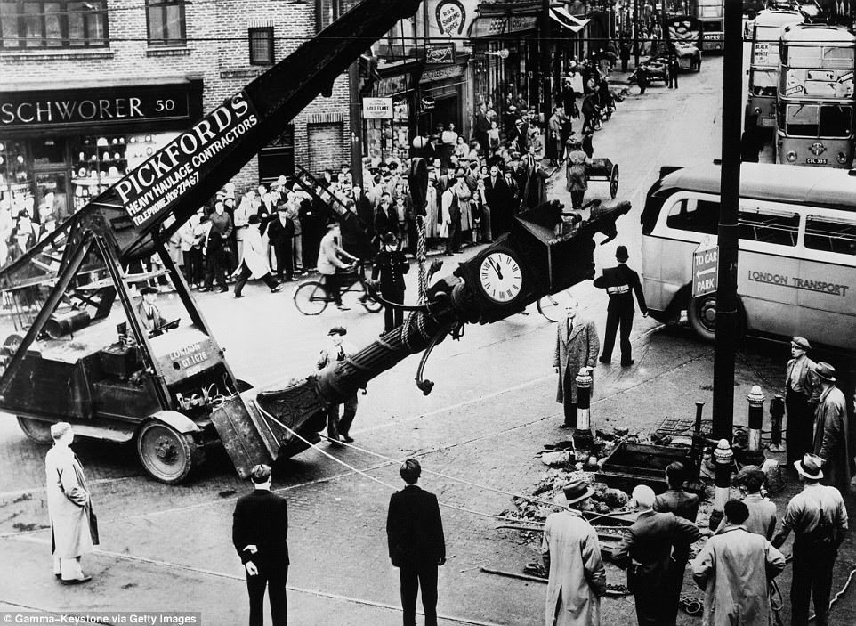 Queen Victoria's Jubilee Clock is moved to another place in front of a crowd of spectators in August 1938