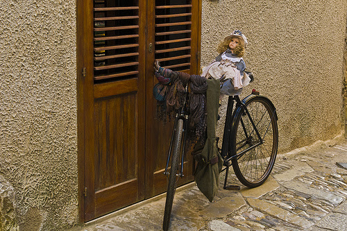 doll on a bike in a doorway