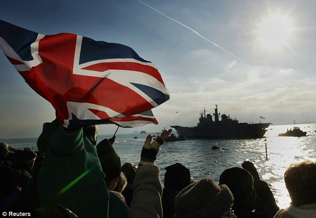 Military might: Wellwishers wave Union flags as HMS Ark Royal sails out of Portsmouth Harbour towards Iraq