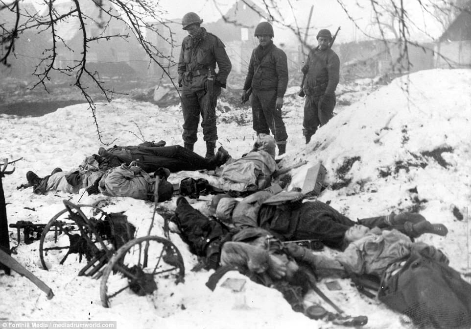 American soldiers come across dead German soldiers in Bastogne during the offensive 