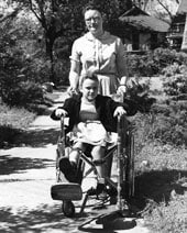 Historic image of woman pushing child in wheelchair