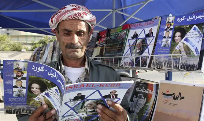 Man reads copy of magazine "Israel-Kurd" at street in Arbil
