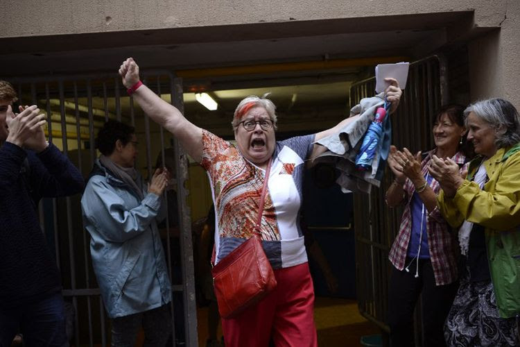 Seorang wanita melepaskan ekspresinya di luar sebuah tempat pemungutan suara setelah memberikan suaranya di Barcelona, Mingu (1/10/2017), untuk referendum kemerdekaan Catalonia. 