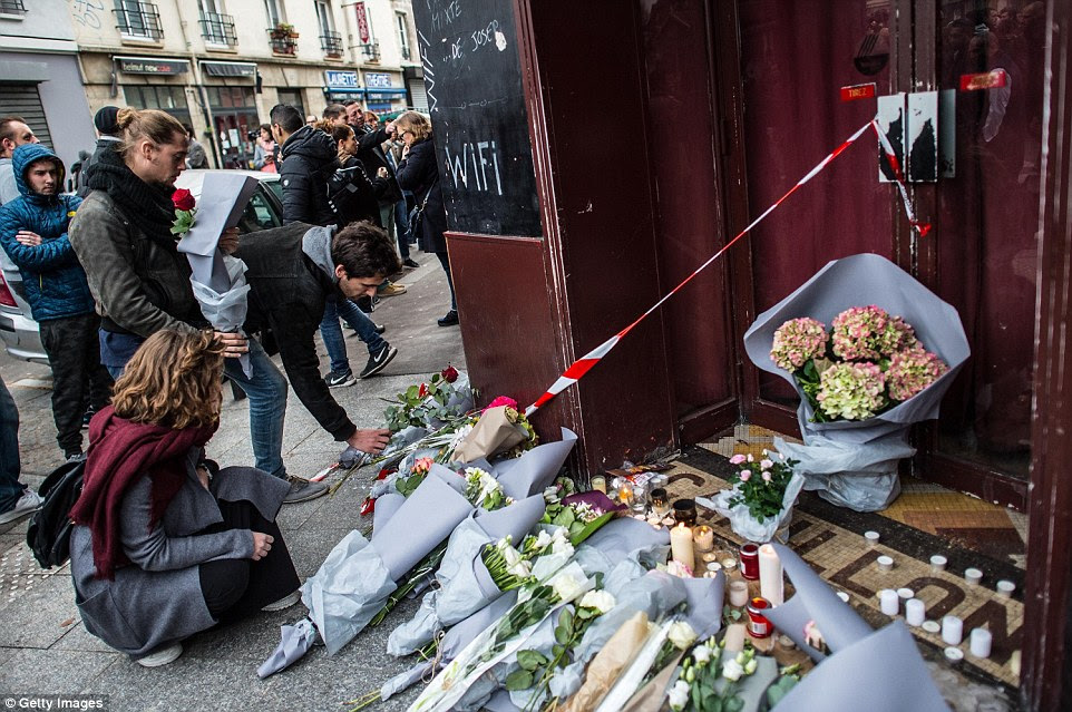 Mourners leave floral tributes at the main entrance of Le Carillon restaurant which was targeted in a series of terrorist attacks in Paris