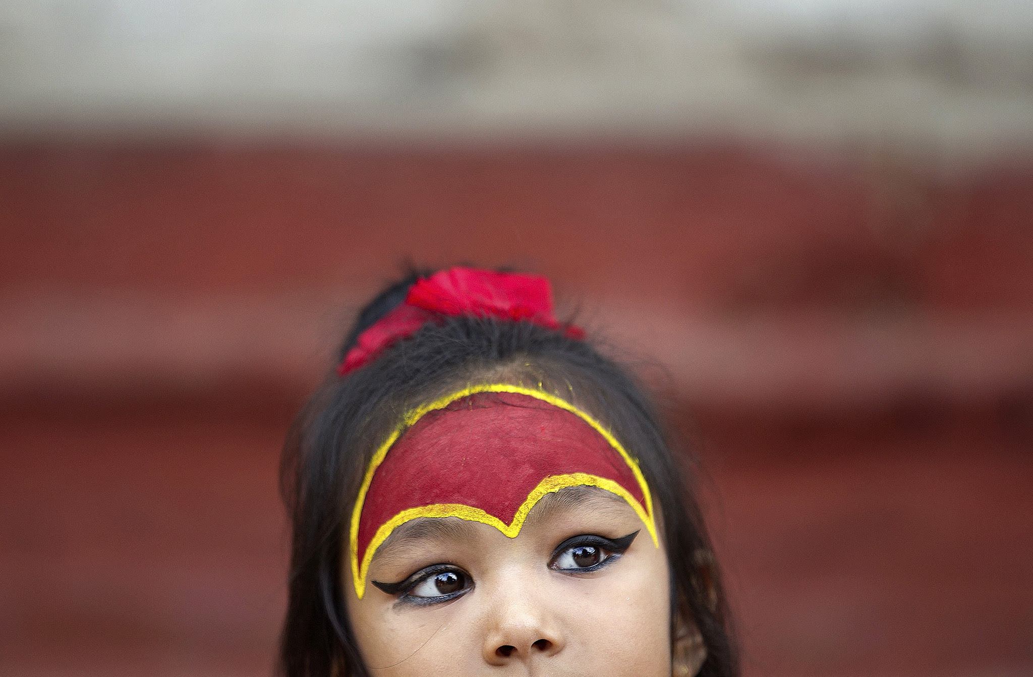A young Nepalese girl wearing traditional attire waits for the Kumari puja to start at Hanuman Dhoka temple, in Kathmandu, Nepal, Wednesday, Sept. 14, 2016. Girls under the age of nine gathered for the Kumari puja, a tradition of worshiping young prepubescent girls as manifestations of the divine female energy. The ritual holds a strong religious significance in the Newar community that seeks divine blessings to save small girls from diseases and bad luck in the years to come. (AP Photo/Niranjan Shrestha)