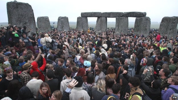 Crowds gather at dawn amongst the stones at Stonehenge
