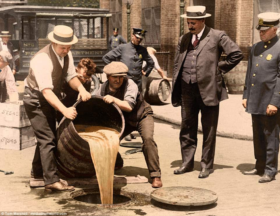 From 1920 to 1933, the US government issued a nationwide constitutional ban on the production, importation, transportation and sale of alcoholic beverages. Now, British colorization expert Tom Marshall, has taken originally black-and-white photos from the era and brought them back to life in full color. Pictured above, New York City Deputy Police Commissioner John A. Leach, right, watching agents pour liquor into sewer following a raid during the height of prohibition
