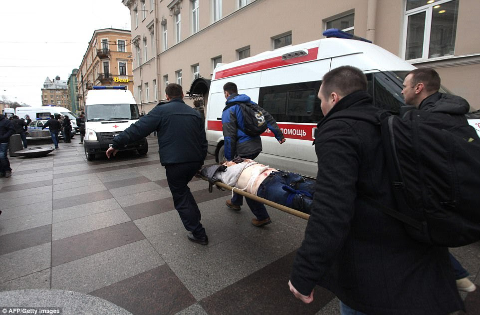 Men carry one of the injured 50 on a stretcher outside Technological Institute metro station in Saint Petersburg on April 3, 2017