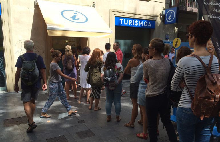 Una decena de personas esperan para entrar en la oficina de turismo de San Sebastián 