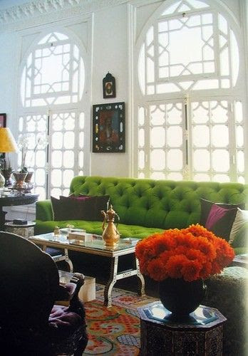 That green couch is gorgeous. The purple cushions and orange flowers really set it off.