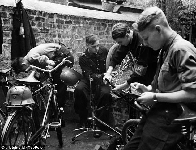 Mobilised for war: Members of the Hitler youth repairing their bikes 