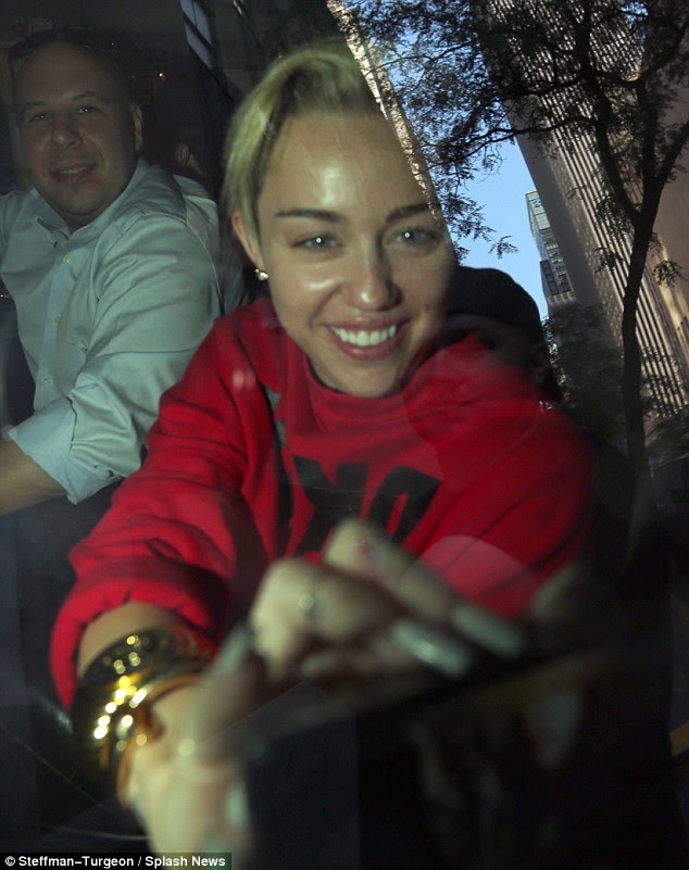 Miley Cyrus arrives fresh-faced and BACK AT IT AGAIN with a VERY STRANGE BRA