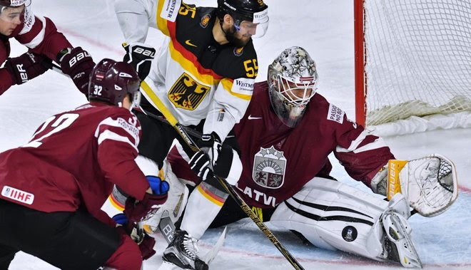 Germany s player Felix Schutz and Latvia s goalie Elvis Merzlikins