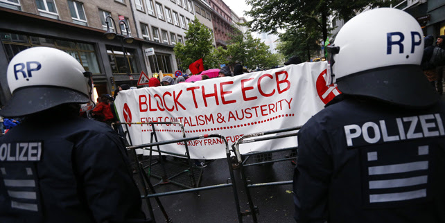 Los manifestantes concentrados delante del BCE, con una pancarta contra las políticas de austeridad impuestas en la UE.