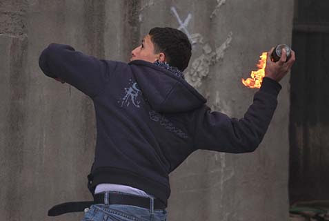 Arab youth throwing a firebomb at Jews.