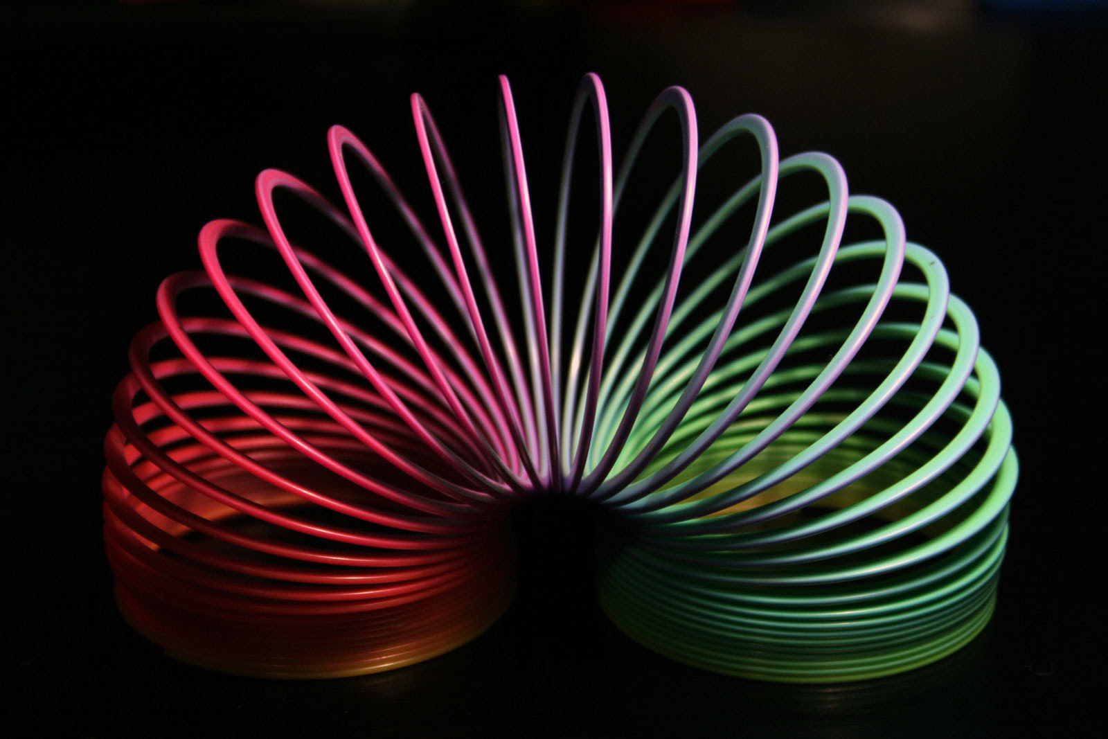 rainbow plastic slinky in arc shape rainbow plastic slinky in arc shape