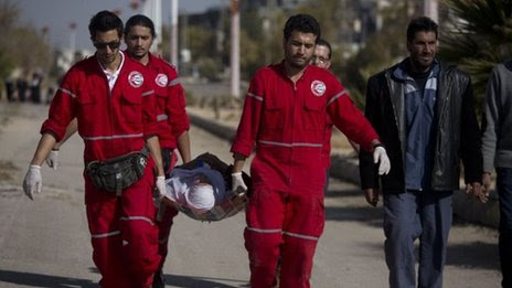 Woman held by Red Crescent workers