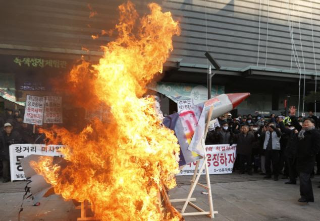 Anger: Anti-North Korean protesters burn a mock North Korean missile, its flag and an effigy of North's leader Kim Jong-Un during a protest blaming the North's rocket launch in central Seoul