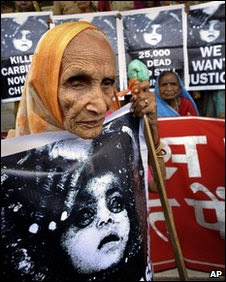 An elderly victim holds a poster outside the court in Bhopal. Photo: 7 June 2010