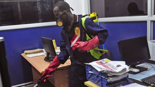 An employee of the Monrovia City Corporation sprays disinfectant inside a government building in a bid to prevent the spread of the deadly Ebola virus (1 August 2014)