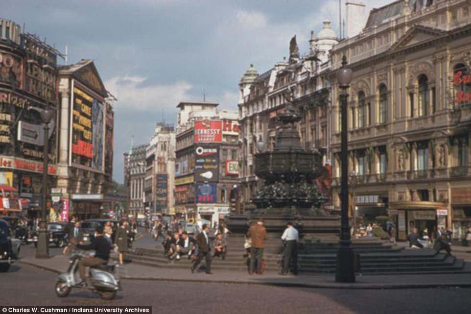 Advertisement boards cover the majorty of building space in this picture of Piccadilly Circus in 1961. Londoners can be seen taking a break from the hustle and bustle of the capital as they rest on the steps of the Shaftesbury Memorial Fountain