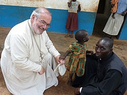 Fr. Joseph with a child in Uganda.