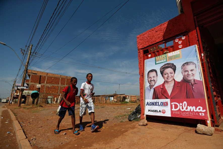 Em cidade satélite de Brasília, crianças passam por propaganda de Dilma, do governador Agnelo Queiroz e do candidato ao senado Geraldo Magela. Os dois petistas foram derrotados, e Dilma ficou em terceiro lugar no primeiro turno no Distrito Federal.
