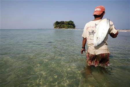 A fisherman carries a fish near Chitthu Island at Ngwesaung Beach February 14, 2010. REUTERS/Soe Zeya Tun