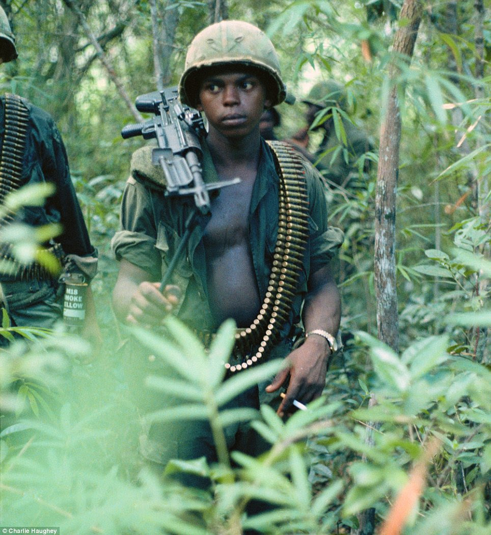 On the march: A machine gun operator walking through the jungle weighed down with guns and ammunition