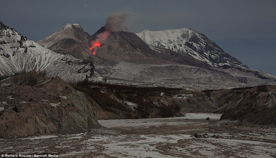 This image shows the glowing rockfall from the Shiveluch volcano in the background, and an erosion gully created by previous eruptions in the foreground.