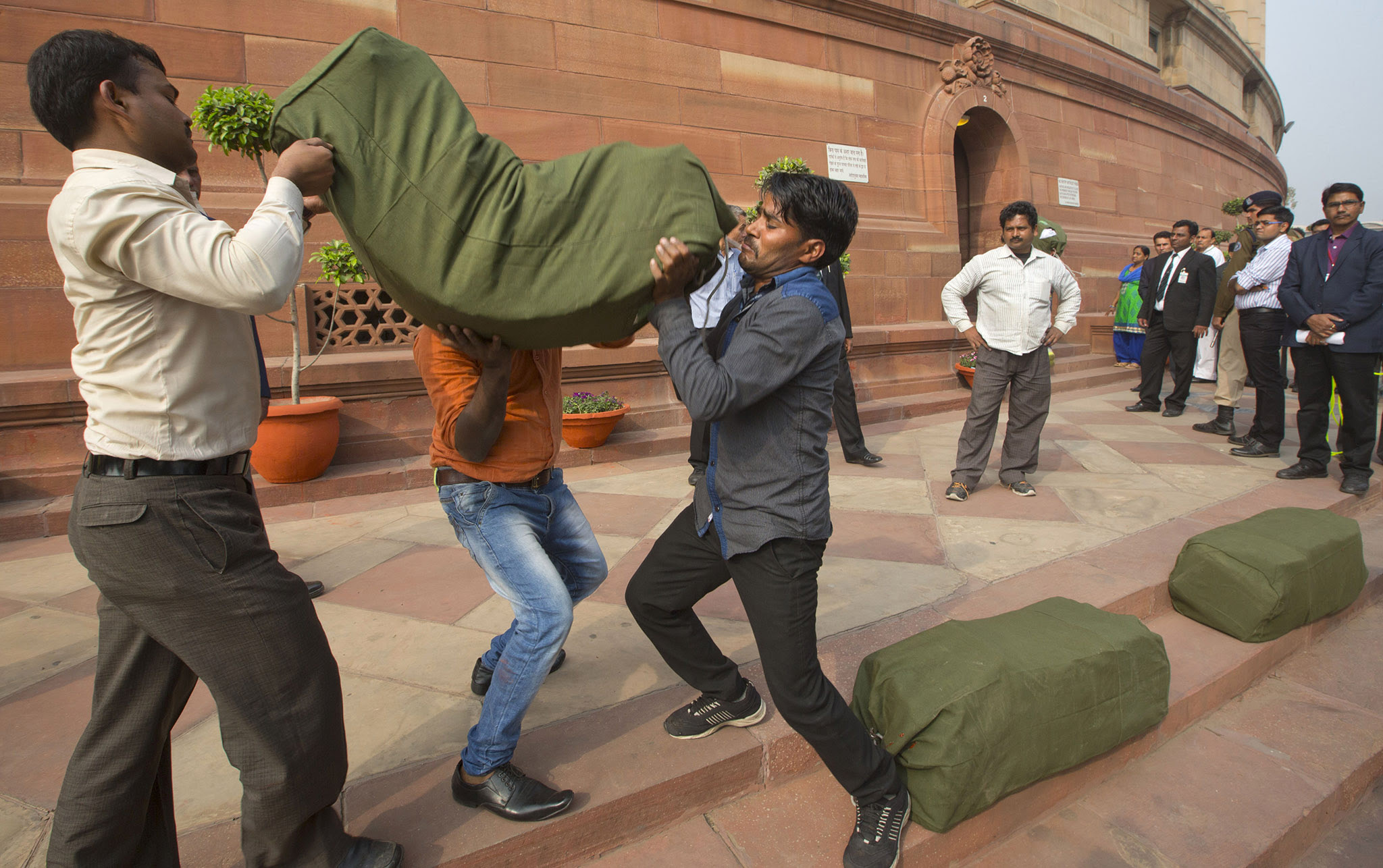Indian workers carry a bag containing copies of the federal budget for the year 2016-17, that will be distributed to lawmakers at the parliament house in New Delhi, India.