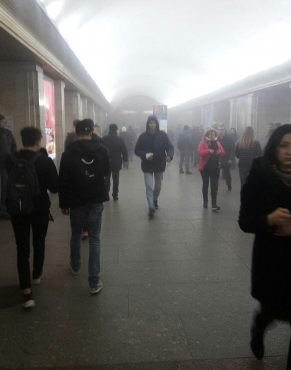  Commuters walk away from the carnage as smoke fills the station in St Petersburg, Russia
