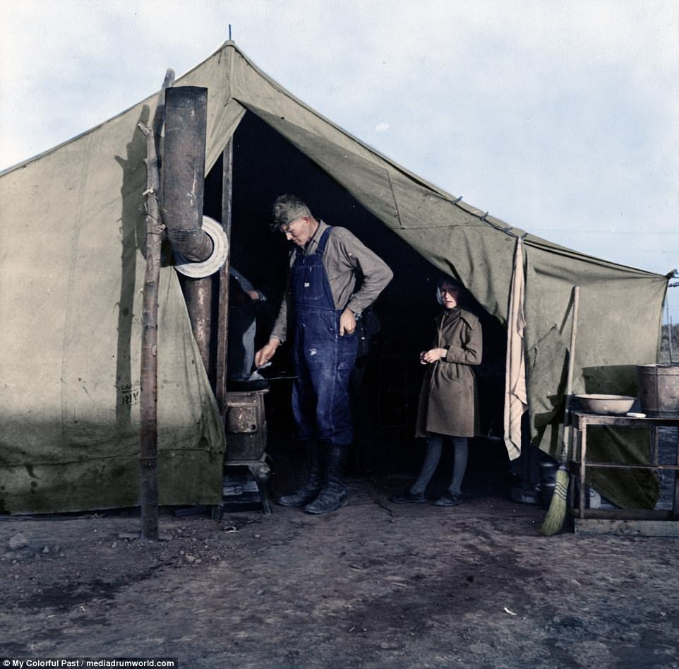 Workers on the pea fields had to be fed in giant tents, like this one in Calipatria, California. Taken in 1939 by Dorothea Lange, this photo shows supper time at the tent. A man in denim overalls is seen leaning over a stove as a child waits expectantly behind him