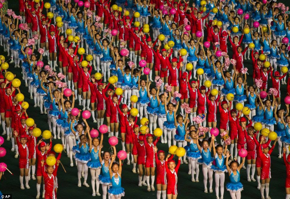 North Korean children dance in unison in an array of bright colours as part of the ceremony