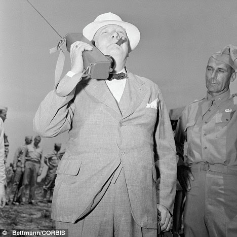 Churchill smokes a cigar while holding a radio to his ear during his visit to Fort Jackson, South Carolina