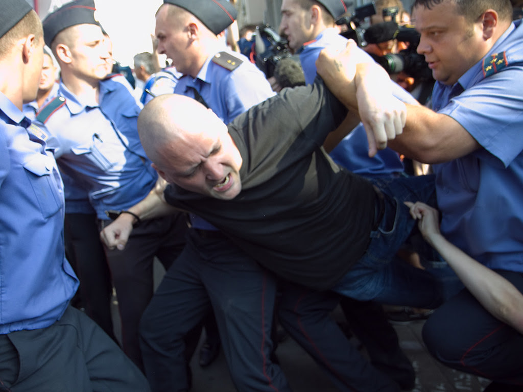 Russian policemen detain Sergei Udaltsov during a protest rally in central Moscow