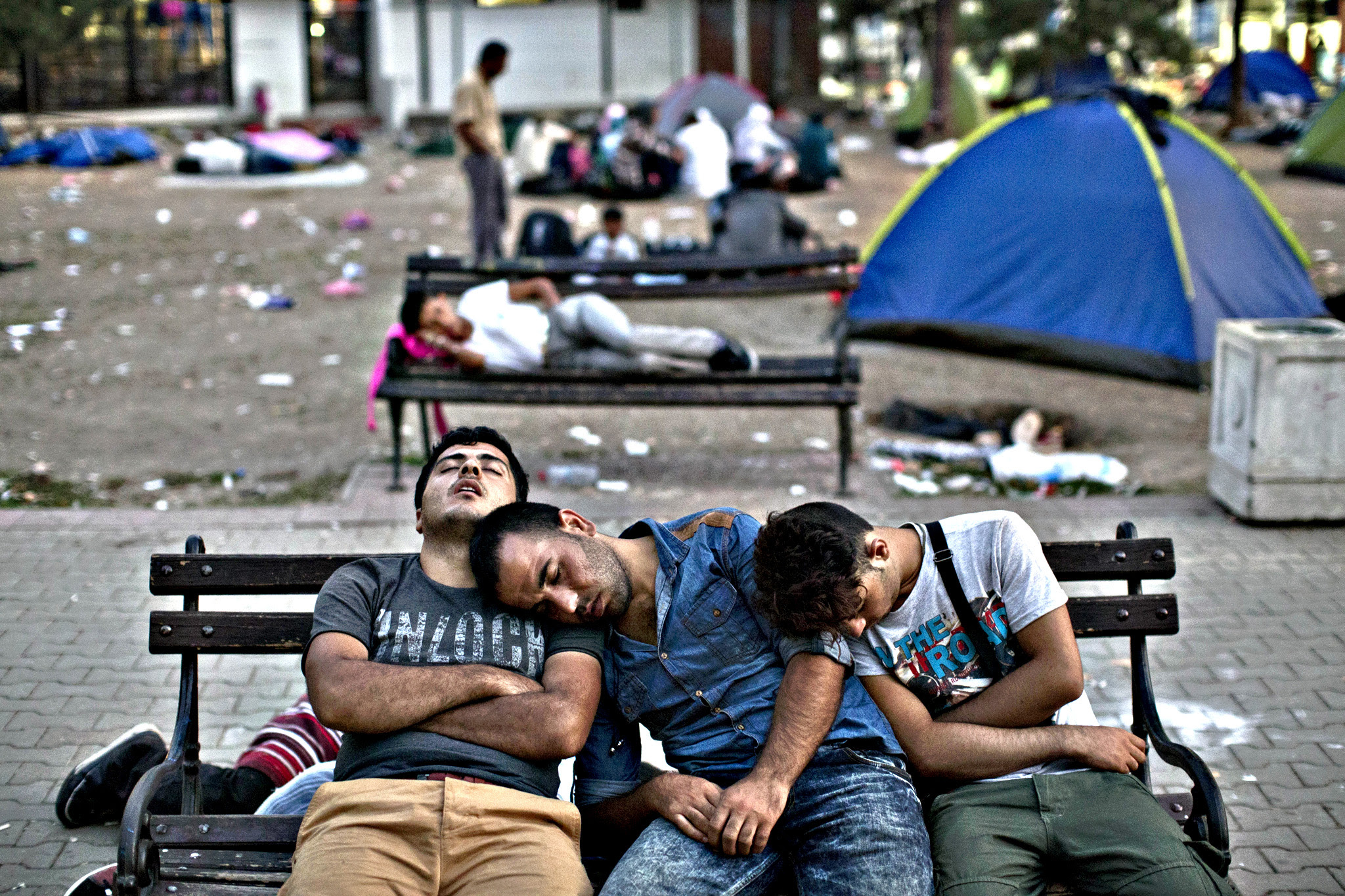 Migrants sleep on a bench at a park in Belgrade, Serbia, Friday, Aug. 28, 2015. Over 10,000 migrants, including many women with babies and small children, have crossed into Serbia over the past few days and headed toward Hungary and the EU Schengen Area, a zone with no internal border checks between member countries