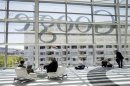 Attendees sits in front of a Google logo during Google I/O Conference at Moscone Center in San Francisco
