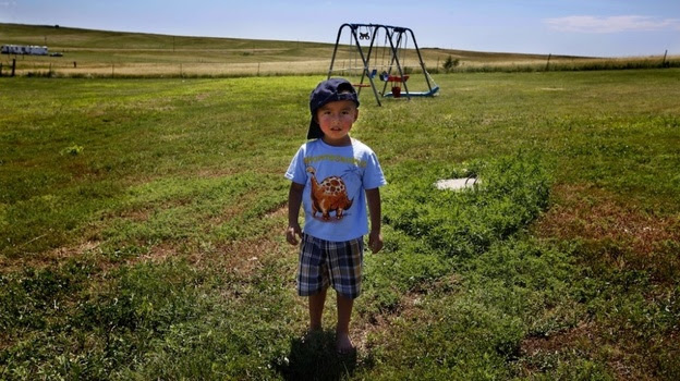 Derrin Yellow Robe, 3, stands in his great-grandparents' back yard on the Crow Creek Reservation in South Dakota. Along with his twin sister and two older sisters, he was taken off the reservation by South Dakota's Department of Social Services in July of 2009 and spent a year and a half in foster care before being returned to his family.