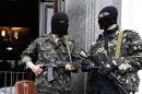 Pro-Russian armed men standb at the entrance to the regional government headquarters in Luhansk