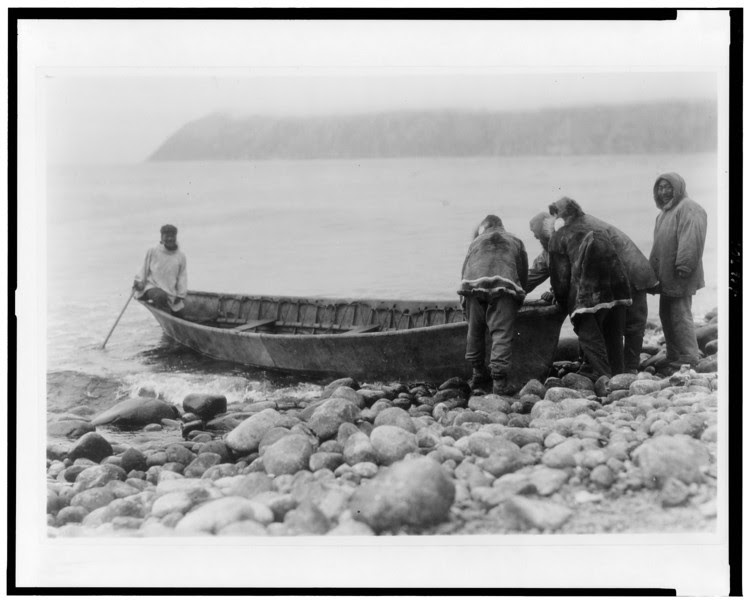 Description of  Title: Launching the boat--Little Diomede Island.  <br />Date Created/Published: c1928.  <br />Summary: Group of men launching boat from rocky shoreline.  <br />Photograph by Edward S. Curtis, Curtis (Edward S.) Collection, Library of Congress Prints and Photographs Division Washington, D.C.